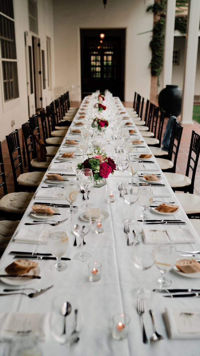 Tablones grandes vestidos con mantel blanco y sobremanteles de colores para evento en Cali